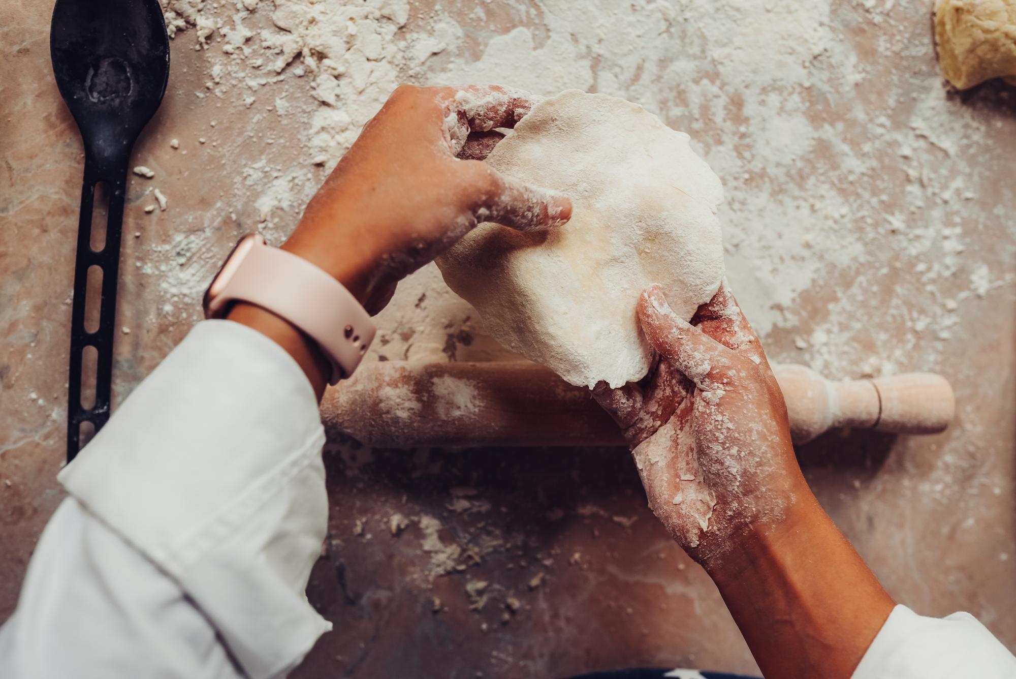 close-up of hands kneading dough